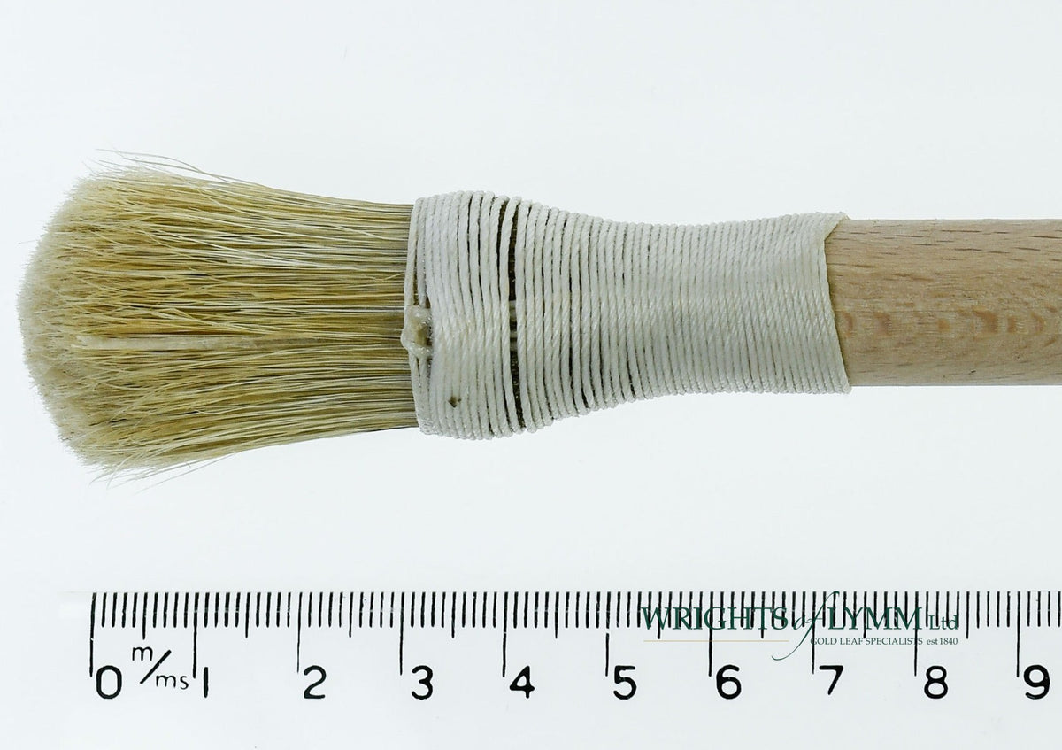 A short, string-bound gesso brush for applying gesso in gilding projects