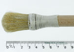 A short, string-bound gesso brush for applying gesso in gilding projects