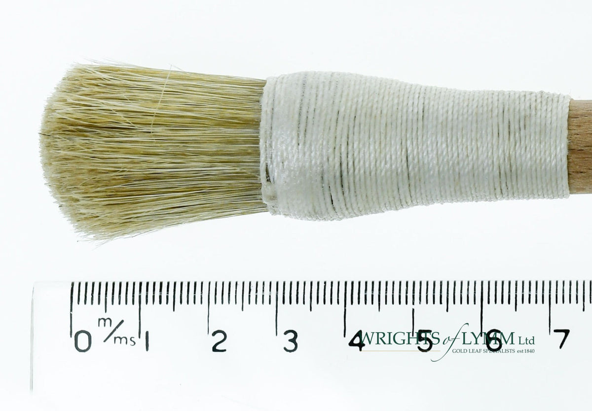 A short, string-bound gesso brush for applying gesso in gilding projects