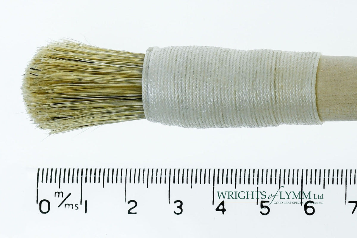 A short, string-bound gesso brush for applying gesso in gilding projects