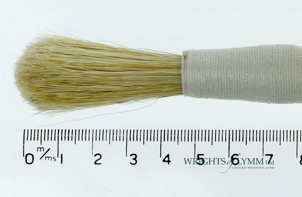A long, string-bound gesso brush for applying gesso in gilding projects