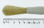A long, string-bound gesso brush for applying gesso in gilding projects