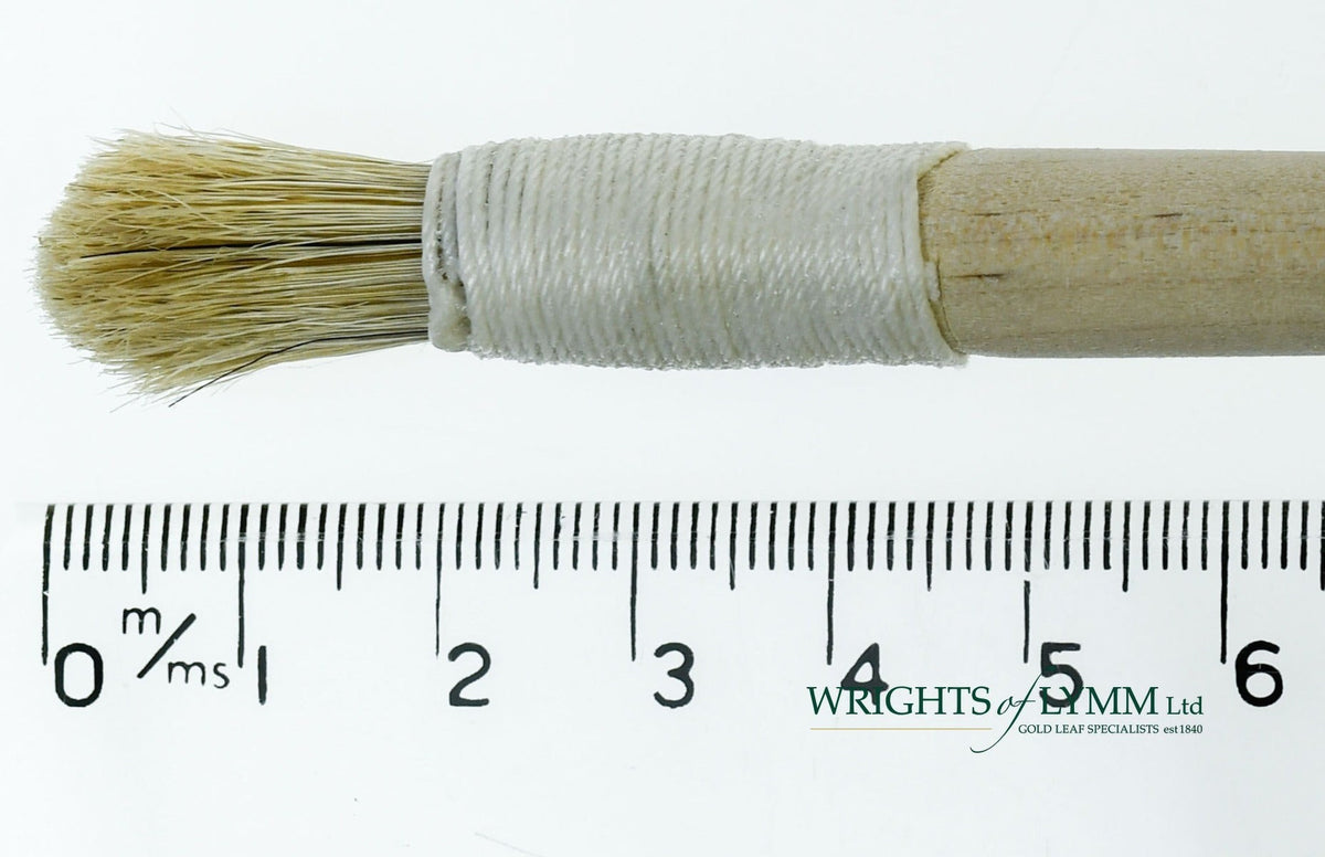 A short, string-bound gesso brush for applying gesso in gilding projects