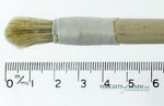 A short, string-bound gesso brush for applying gesso in gilding projects