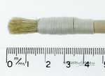 A short, string-bound gesso brush for applying gesso in gilding projects