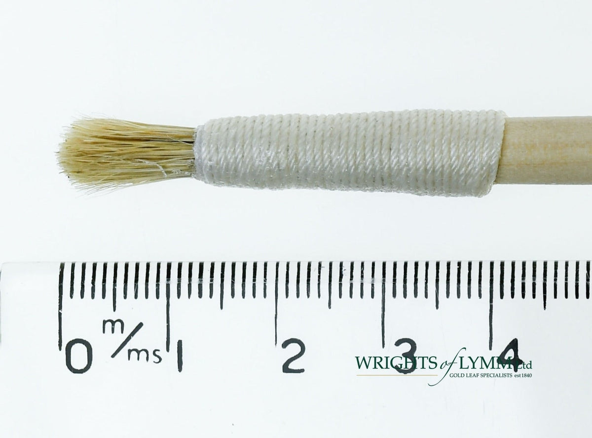 A short, string-bound gesso brush for applying gesso in gilding projects