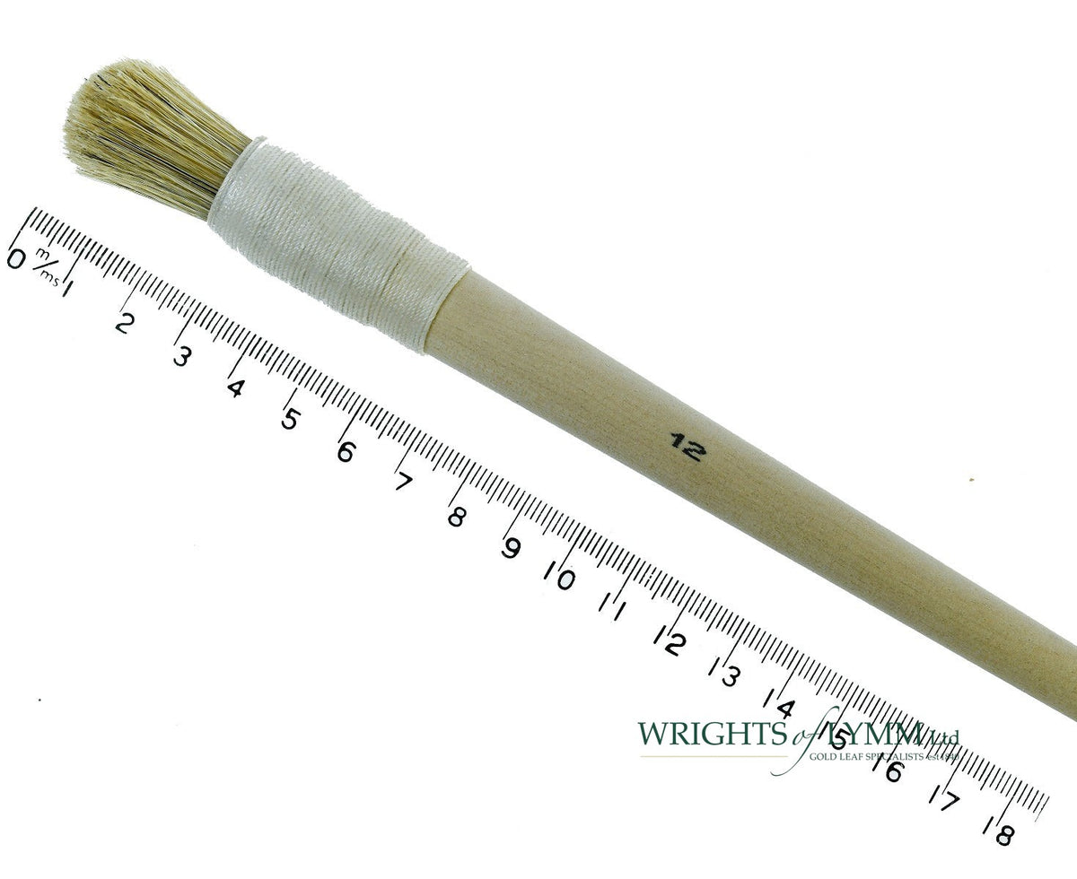 A short, string-bound gesso brush for applying gesso in gilding projects